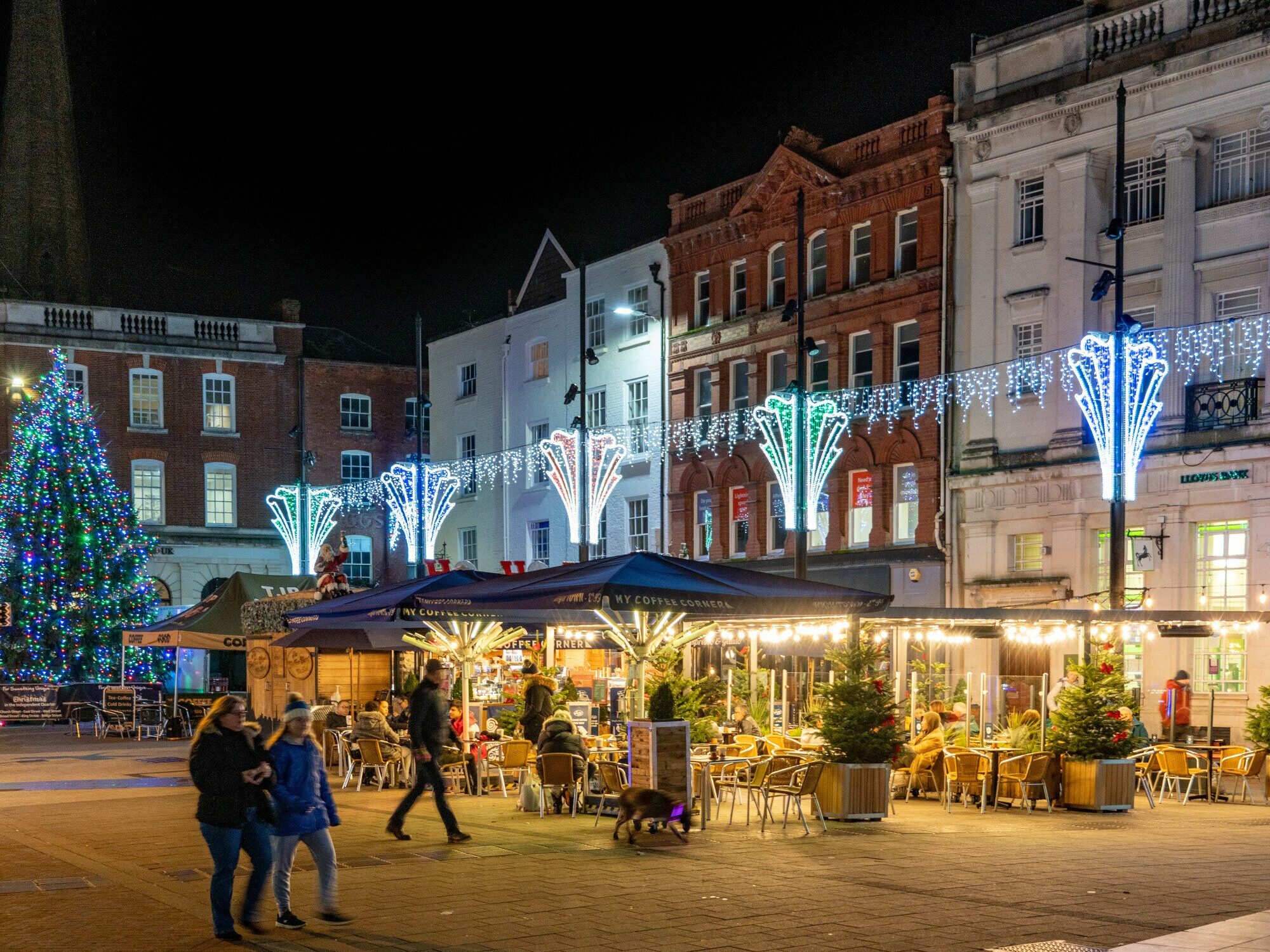 Hereford city centre at night with Christmas lights, a large tree and festive market stalls during Hereford Christmas Market.