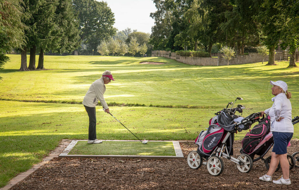 Golfers practicing swings with club hire equipment on the Pearl Lake course.