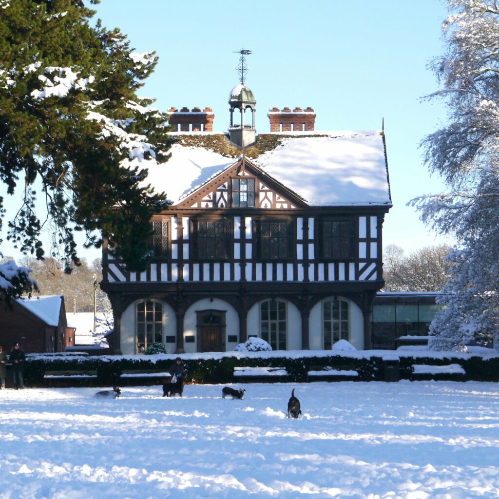 Snow-covered Grange Court in Leominster with people and dogs playing in the snow during Leominster Christmas Market.