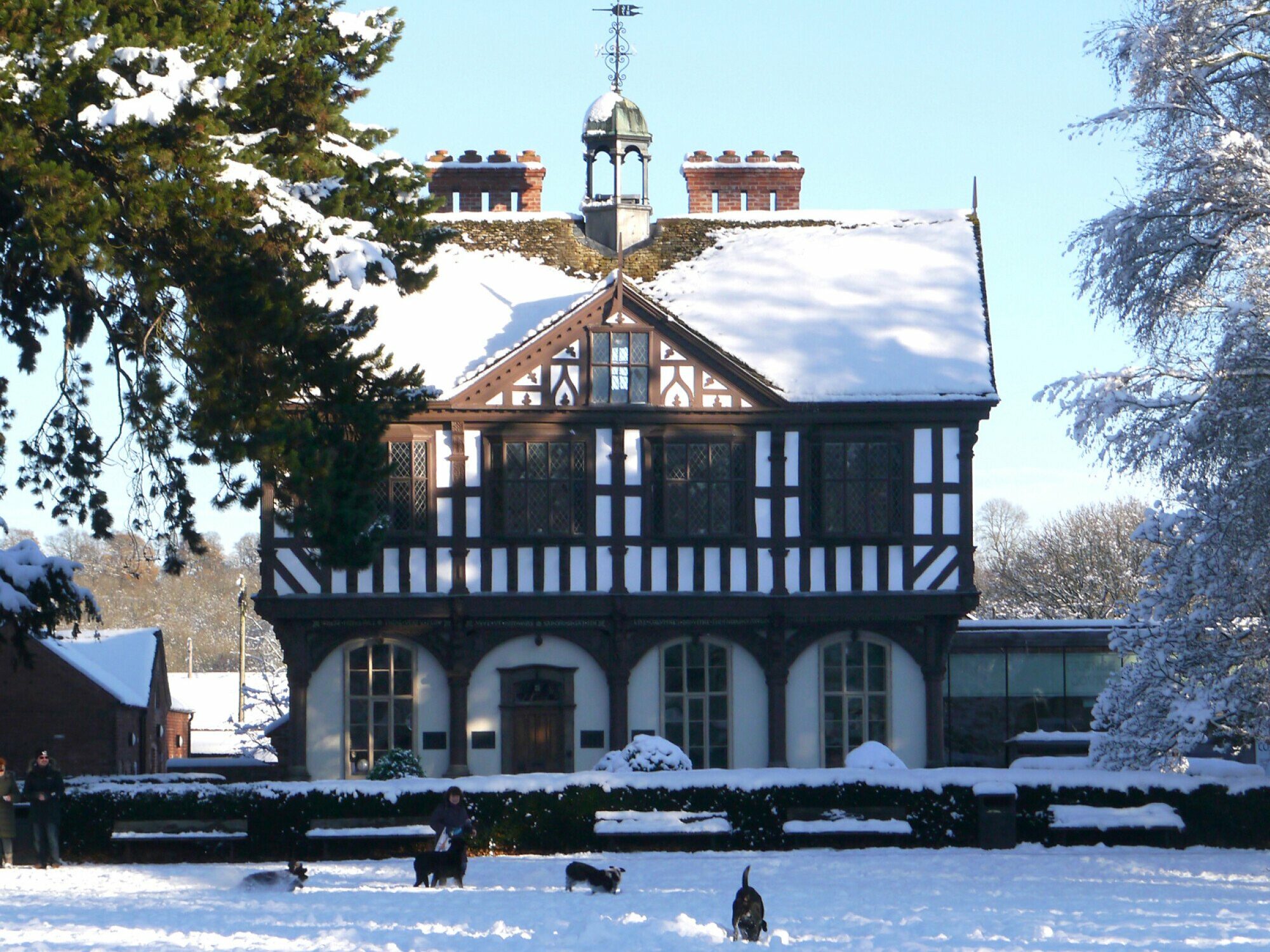 Snow-covered Grange Court in Leominster with people and dogs playing in the snow during Leominster Christmas Market.