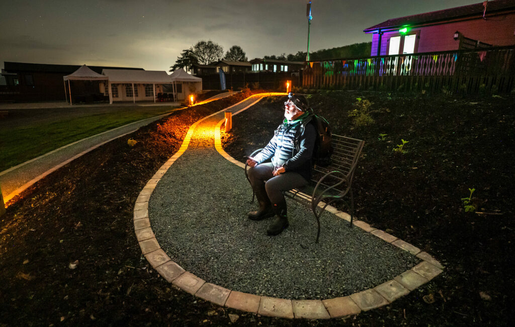Holidaymaker looking into the night sky on a stargazing holiday at Rockbridge holiday park, Wales